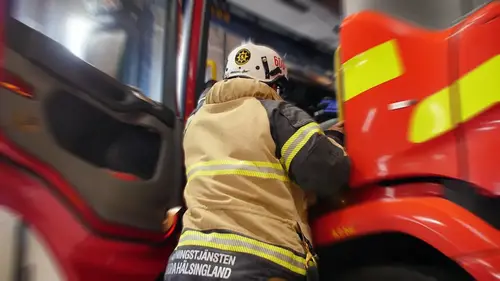 En brandman kliver in i en brandbil